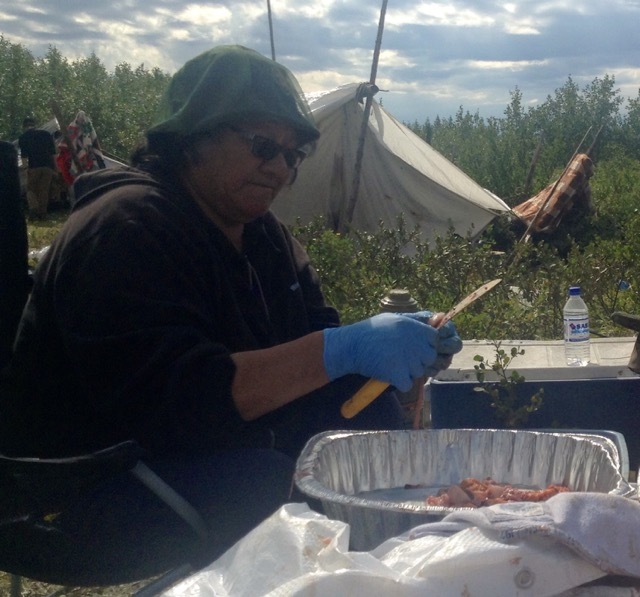 Annie Wabano cutting up fish during a youth camping trip back in August.